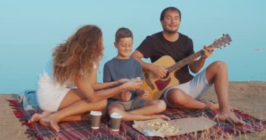 Aile, tepede piknik yaparken ve kahve ve pizza ile atıştırmalık şeyler yaparken aktif olarak iletişim kuruyor.