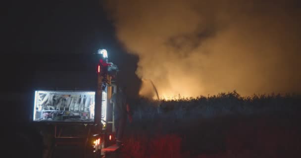Brandweerwagen met knipperend licht op achtergrond brandend veld. — Stockvideo