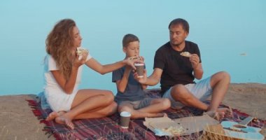 Aile, tepede piknik yaparken ve kahve ve pizza ile atıştırmalık şeyler yaparken aktif olarak iletişim kuruyor.