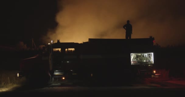 Brandbil med blinkande ljus på bakgrund brinnande fält. — Stockvideo