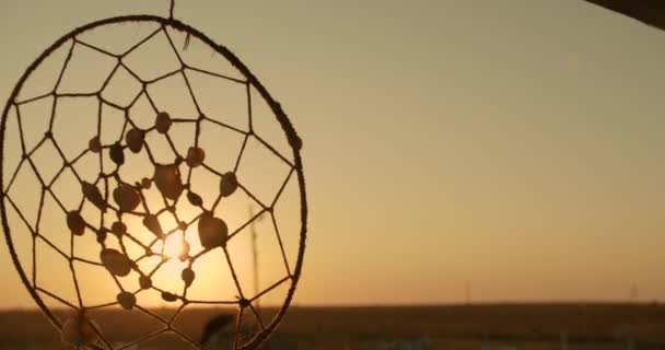 Native American dreamcatcher hanging in breeze at sunset. — Stock Video