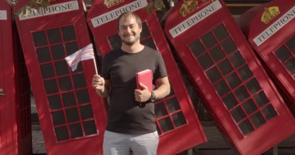 Der Mann mit britischer Flagge und Buch, Ausbildung im Ausland, Spracherwerb. — Stockvideo