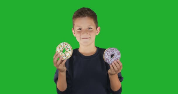 Fecha a porta. retrato de um cara engraçado, se divertindo com donuts coloridos contra o rosto. Expressões, conceito de dieta, cor de fundo. 4k . — Vídeo de Stock