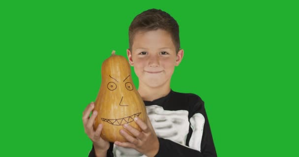 Маленький мальчик в костюме с тыквой, улыбающийся на вечеринке в честь Хэллоуина на зеленом фоне с хромовым ключом . — стоковое видео