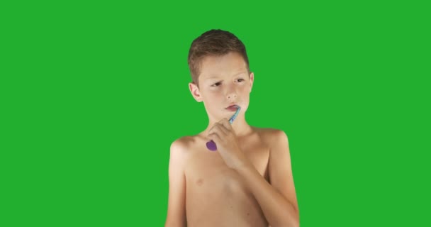 Gyönyörű fiú fogmosás a zöld képernyőn. — Stock videók