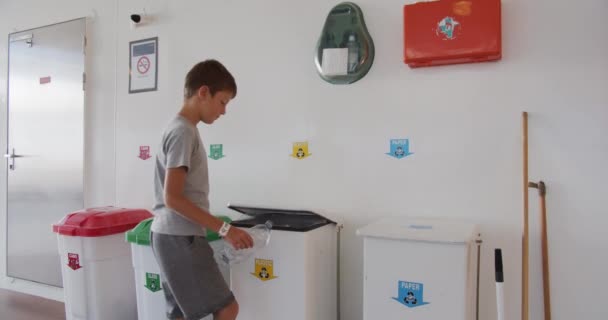 Il ragazzo butta rifiuti in bidoni colorati e di plastica. Smistamento e riciclaggio dei rifiuti, salvaguardia dell'ambiente. Smistamento dei rifiuti domestici, compostaggio, zero rifiuti. Smistamento della spazzatura . — Video Stock