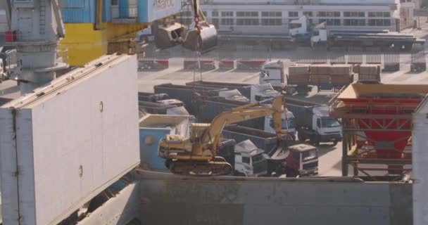 Casablanca, Marokko - 15 oktober 2019: Havenkraan tilt een graafmachine op. Kranen laden en lossen vracht van schip in de haven. — Stockvideo