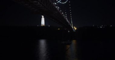 Ponte 25 de Abril, Lizbon Portekiz 'in havadan görünüşü gece Tejo Nehri üzerinde uçuyor..