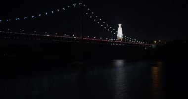 Ponte 25 de Abril, Lizbon Portekiz 'in havadan görünüşü gece Tejo Nehri üzerinde uçuyor..