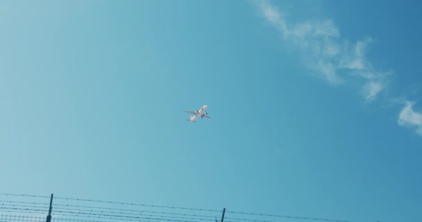 Avión de pasajeros está aterrizando contra el cielo azul con nubes . — Vídeo de stock