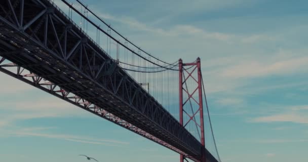Αεροφωτογραφία. Κάτω από τη γέφυρα. Γέφυρα αναστολής πάνω από τον ποταμό Τάγκους στη Λισαβόνα. 25η Απριλίου γέφυρα σύμβολο της Πορτογαλίας στον ήλιο λάμπει. — Αρχείο Βίντεο