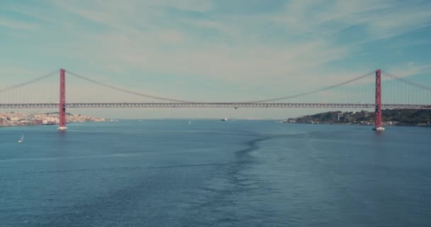 Вид с воздуха. Мост через реку Тагус в Лиссабоне. 25 апреля - символ Португалии в лучах солнца . — стоковое видео