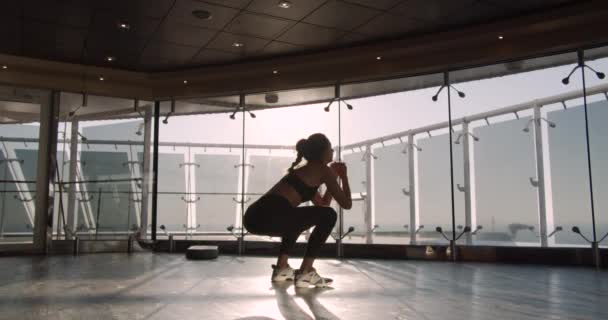 Fitnessfrau beim Kniebeugen. Szene in der Turnhalle. — Stockvideo