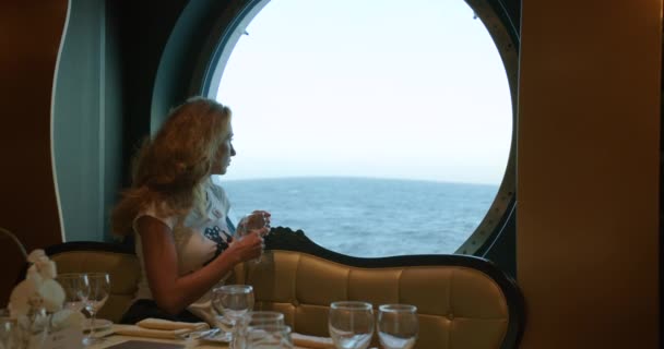 Γυναίκα κάθεται σε εστιατόριο σε κρουαζιερόπλοιο. Κρουαζιέρα στον ωκεανό. — Αρχείο Βίντεο