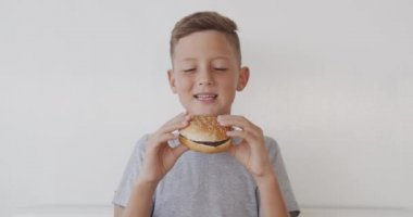 Mutlu çocuk lezzetli fast food burgeri yiyor..