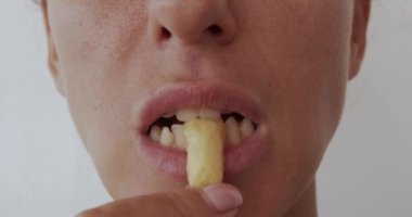 Patates kızartması yiyen kadın, zararlı ve lezzetli fast food, yakın plan..