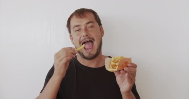 Feliz hombre comiendo papas fritas. Salud y concepto de alimentos . — Vídeos de Stock