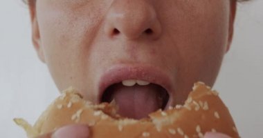 Hamburger yiyen bir kadın, sağlıksız yemek, yakın plan dudaklar..
