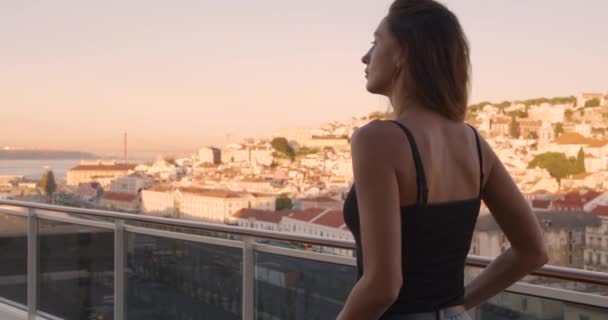 Lizbon 'un tarihi şehrinde gezinen bir kadının yan görüntüsü Lizbon' un pitoresk manzarasına bakıyor.. — Stok video