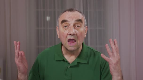 Senior man vertelt iets, het openen van zijn tandloze mond wijd. Close-up portret. — Stockvideo