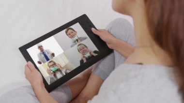 Video konferans teknolojisi kullanan kadın iş arkadaşlarıyla evlerinde ve ofislerinde görüntülü konuşma yapıyor..