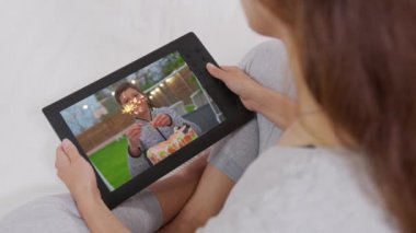 Annem oğluyla doğum gününde iletişim kuruyor. Web kamerasında gösterilen mumlu pasta. Ev karantinası, sosyal uzaklık, kişisel izolasyon..