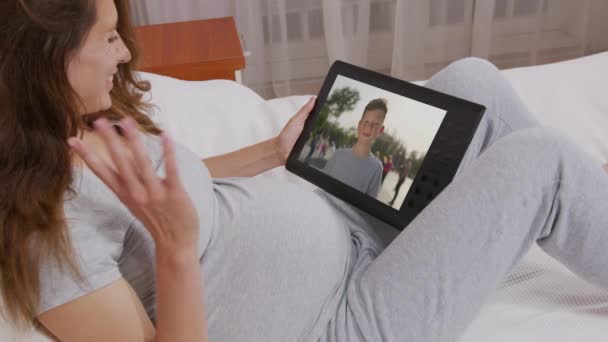 Moeder en zoon communiceren via videochat op tablet. Zelfisolatie, quarantaine, pandemisch concept. — Stockvideo