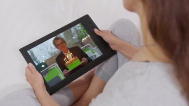 Bir kadın, video aramasıyla büyükbabasını tebrik ediyor. Ev karantinası, sosyal uzaklık, kişisel izolasyon..