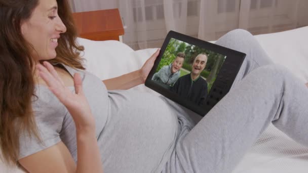 Młoda kobieta mama wideo rozmowy na laptopie rozmowy przez kamerę internetową ze szczęśliwym chłopcem i dziadkiem na ekranie komputera. Wideokonferencje, rozmowa rodzinna. Przez ramię widok z bliska. — Wideo stockowe