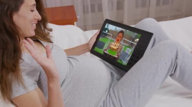 Küçük bir çocuğun doğum gününde pastaya mum üflediği videoyu izlediği akıllı telefon cihazını tutan genç kadının omzunun üstünden bakın. Yakın çekim..