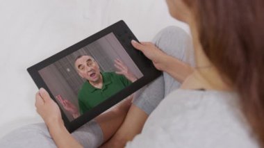 Genç yetişkin bir kadın, dizüstü bilgisayar ekranından yaşlı babayı arıyor. Web kamerasıyla konuşan bir kadın. Video çağrısı, aile sohbeti kavramı.