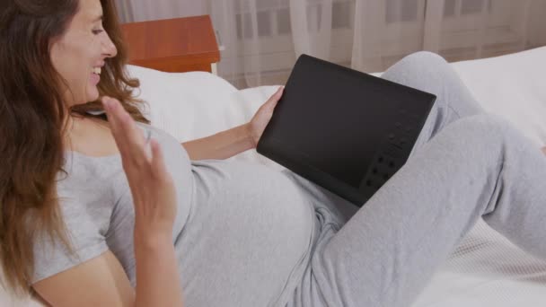 Jovem mãe ter vídeo chat conversando com mostrando barriga maternidade na tela falando com alguém . — Vídeo de Stock