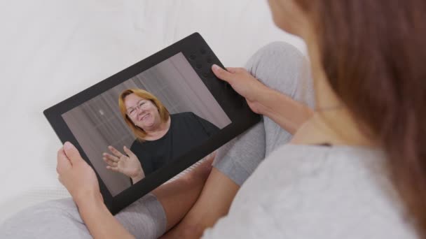 Mujer joven que recibe videollamada a través de una tableta hablando con mamá. amigos, tiempo de la cara, en línea, internet, comunicación de larga distancia, concepto de chat . — Vídeos de Stock