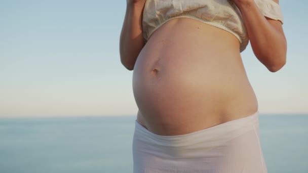 Ženské ruce držící těhotenský test proti těhotnému břichu, plánování rodičovství. — Stock video