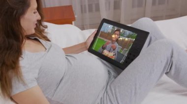 Annem oğluyla doğum gününde iletişim kuruyor. Web kamerasında gösterilen mumlu pasta. Ev karantinası, sosyal uzaklık, kişisel izolasyon..