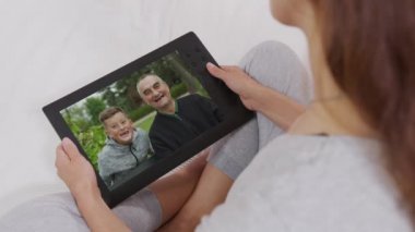 Genç kadın anne videosu dizüstü bilgisayardan arıyor mutlu çocuk ve büyükbaba ile webcam aracılığıyla bilgisayar ekranında konuşuyor. Videocall, aile sohbeti konsepti. Omuz üstü yakın görünüm.