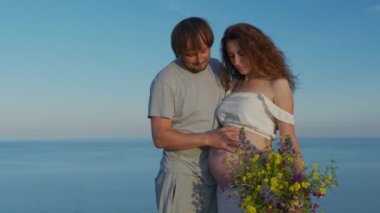 Anne ve babanın elleri hamile karnında. Hamile bir çift hamile karnını okşuyor. Bekleyen anne bakımı. Annelik konsepti. Hamilelik.