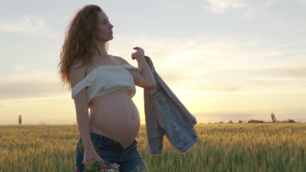Pregnant woman with a bouquet of wildflowers — Stock Video