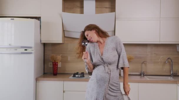 Mamá embarazada escuchando música y bailando en casa en la cocina. Retrato Mujer de pie en la cocina Día soleado . — Vídeo de stock