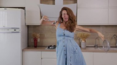 Joy ve Eğlenceli Hamile Anne Etkin Dans Etme ve Hazırlama Yemeği. Mutlu Duygular Genç Anne. Neşeli Kadın Keyifli Şarkı. Aile kavramı.