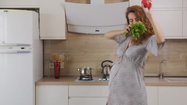 Buon concetto di gravidanza sana. Donna incinta che balla e cucina in cucina. — Video Stock
