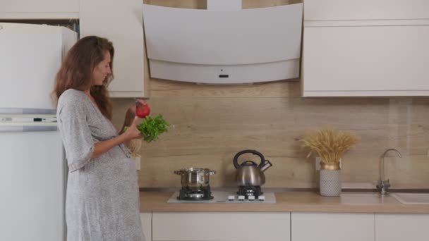 Bonita mujer cocinando sopa en la cocina. Primer plano de ama de casa preparando la cena en casa. Mujer joven degustación de sopa en cuchara en la cocina moderna. — Vídeo de stock