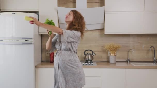 Hermosa mujer embarazada preparando comida y bailando con verduras en la cocina . — Vídeo de stock