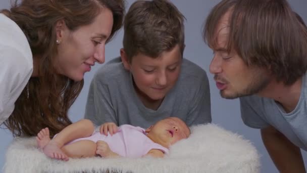 Madre padre e hijo besan a una niña recién nacida. Reposición en la familia. Concepto familiar . — Vídeos de Stock