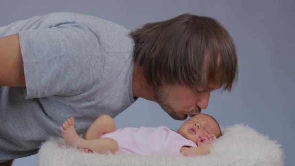 Gururlu baba, birbirlerine bakarken küçük kızına sarılıyor. Babam burunlarını yeni doğmuş bebeğiyle ovalıyor ve gülümsüyor. Yavaş çekim. — Stok video