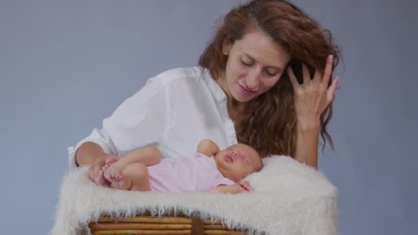 사랑많은 아기를 즐겁게 돌보고 있는 사랑 스런 엄마에게 부드럽게 키스를 하는 아기가 갓 태어난 아기와 건강 한 육아를 함께 나누는 모습. — 비디오