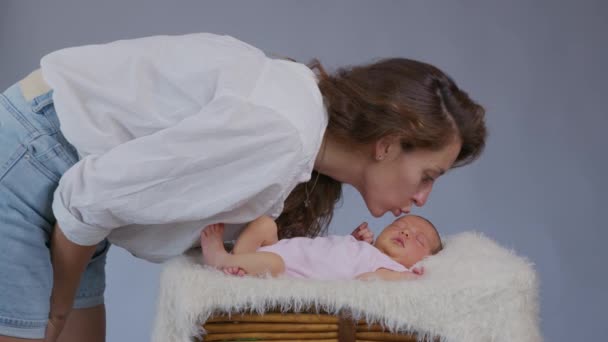 Annesinin bebeğini nazikçe öpmesi, annesini sevmesi, bebeğiyle ilgilenmesi, yeni doğan çocuğuyla olan bağını paylaşması, sağlıklı çocuk bakımı.. — Stok video