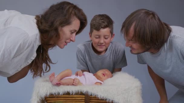 Anne, baba ve oğul yeni doğmuş bir kızı öpüyor. Ailede tazeleme. Aile kavramı. — Stok video