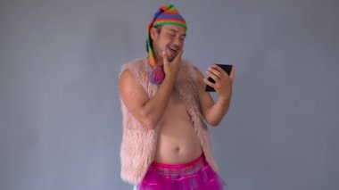 Genç, komik ucube. Bir mim kostüm. Eşcinsel adam. Komik adam aynaya bakıyor..