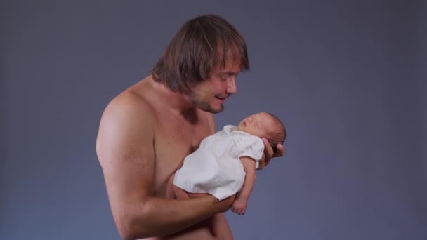 Pyšný otec se mazlí se svou holčičkou, jak na sebe zírají. Táta si tře nosy s novorozencem v náručí a usmívá se. Zpomalený pohyb. — Stock video